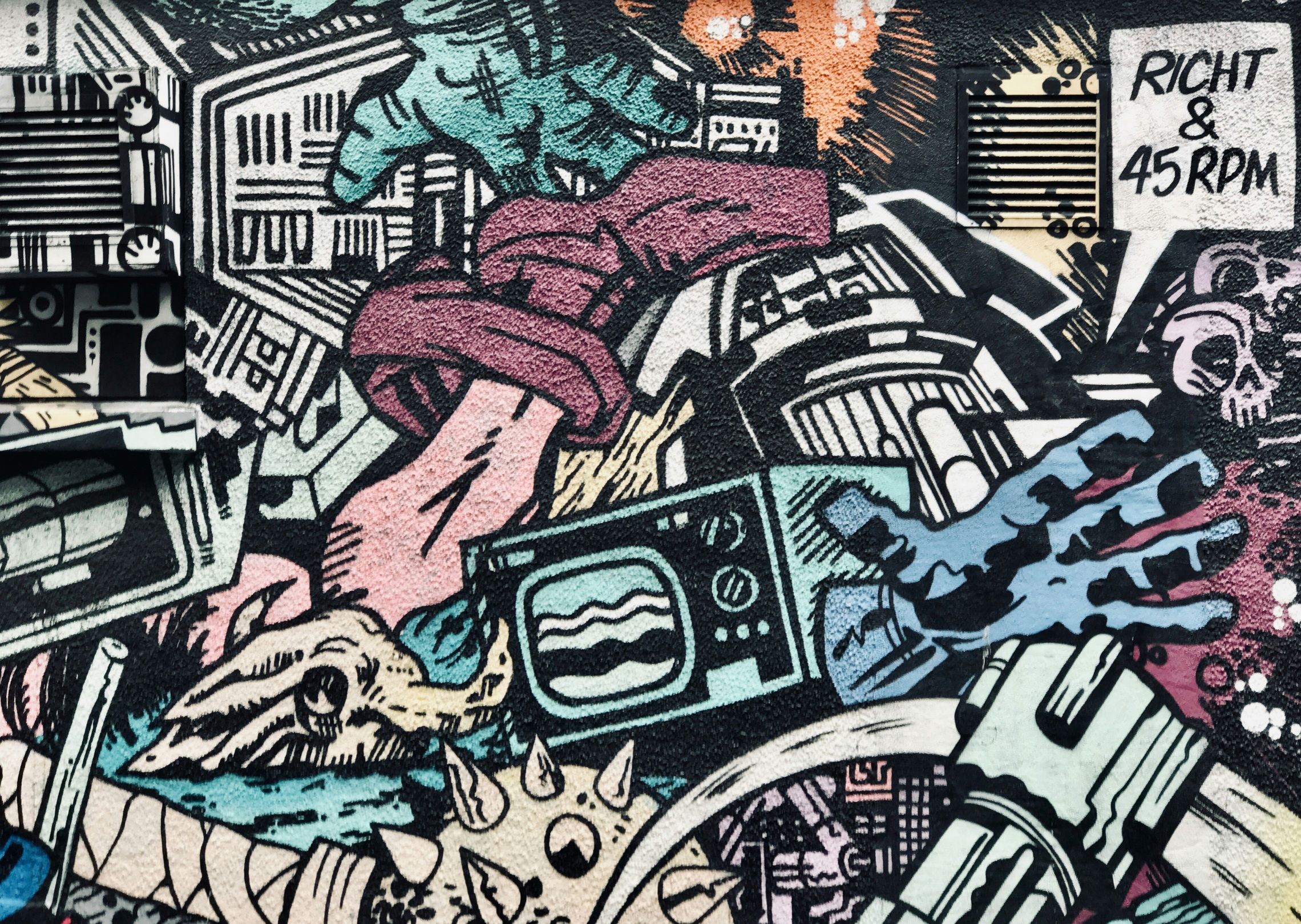 A dense, surreal street art doodle featuring a mix of organic and mechanical forms