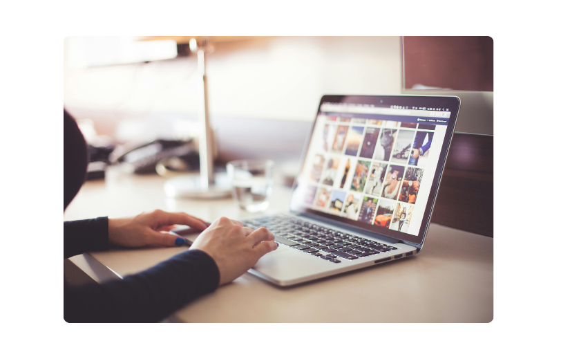 شخص يتصفح الصور على جهاز كمبيوتر محمول ، يمثل كيفية بدء عمل تجاري عبر الإنترنت وبناء علامة تجارية من خلال المحتوى المرئي.