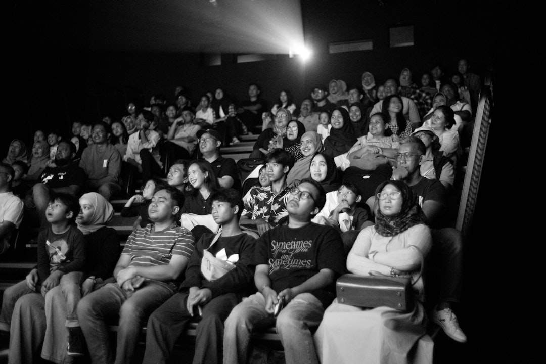 Un public care râde într-un cinematograf.