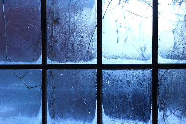 Christmas background with snow, ice, and frosted windows