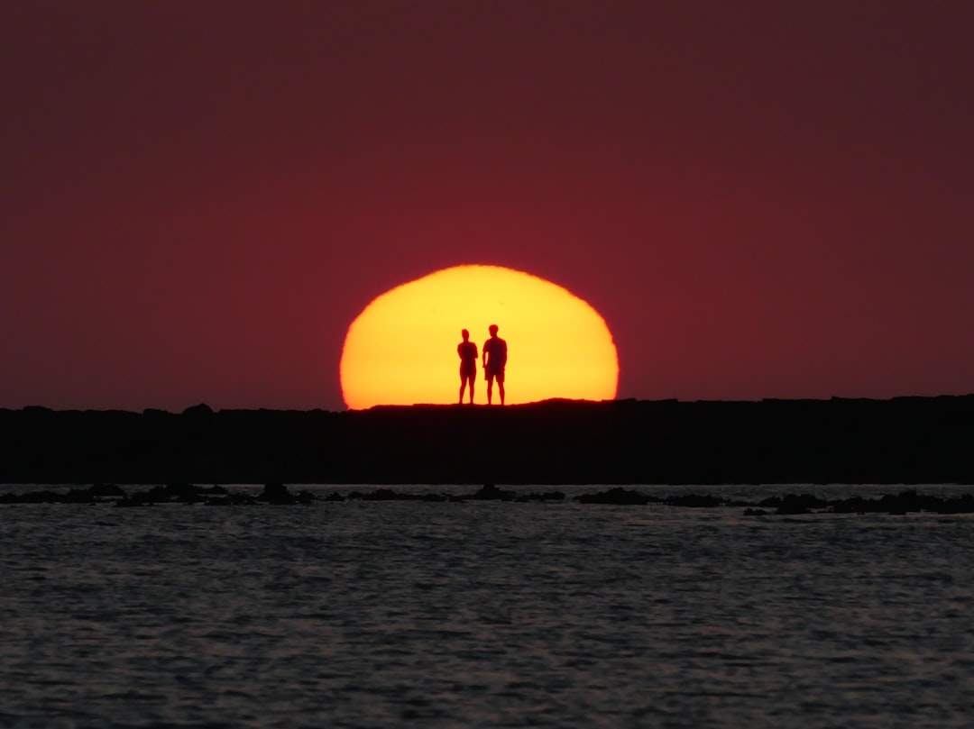 Ein Paar als Silhouette vor einem Sonnenuntergang, das für Liebe und Beziehungen steht.