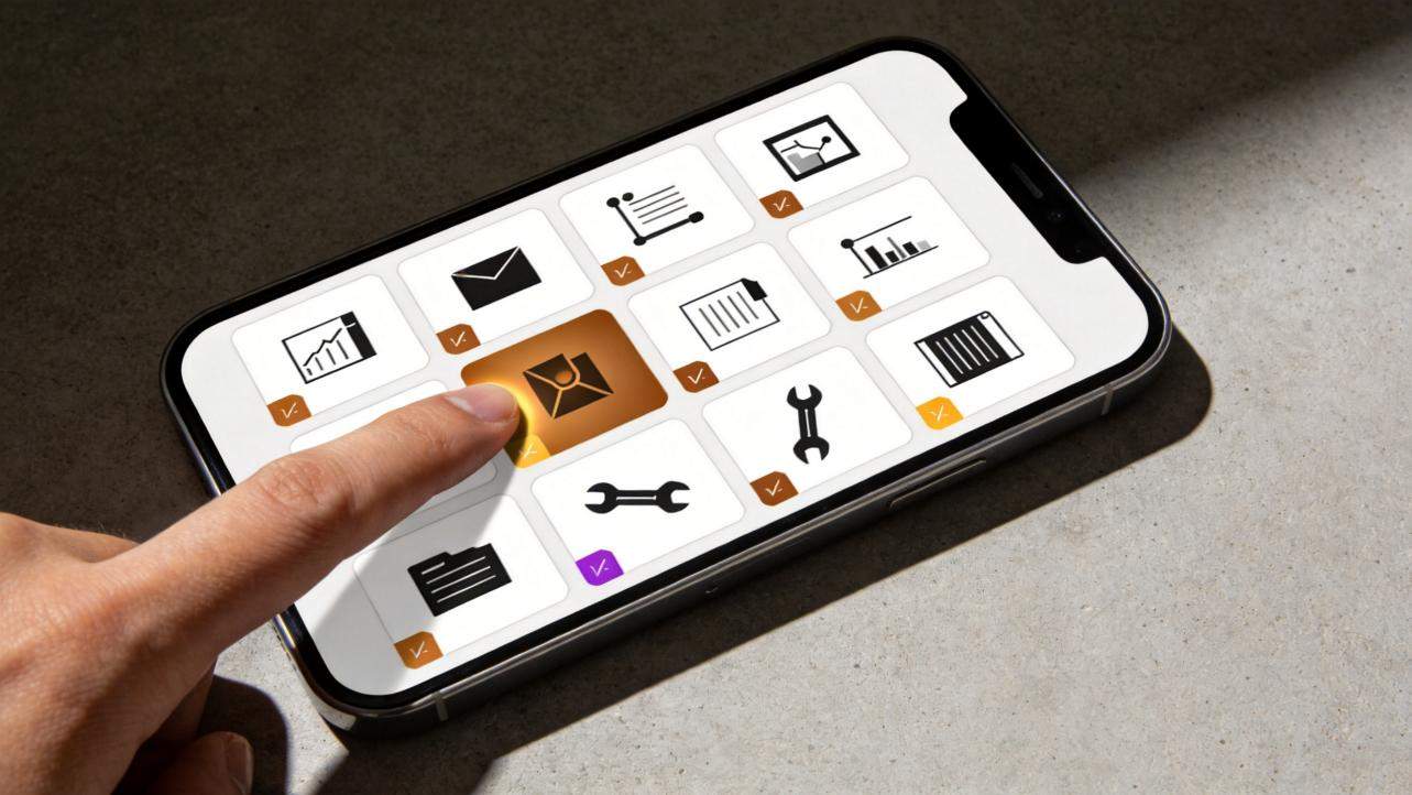 Finger tapping an orange tile on a phone screen with a grid of app icons