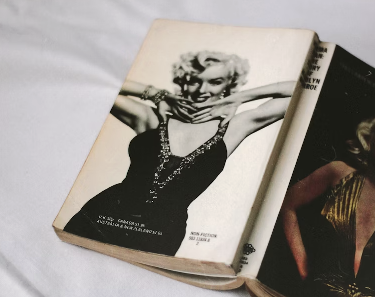 A glamorous black and white photo of Marilyn Monroe, smiling elegantly, with the article title "60+ Timeless Marilyn Monroe Quotes" in a stylish font.