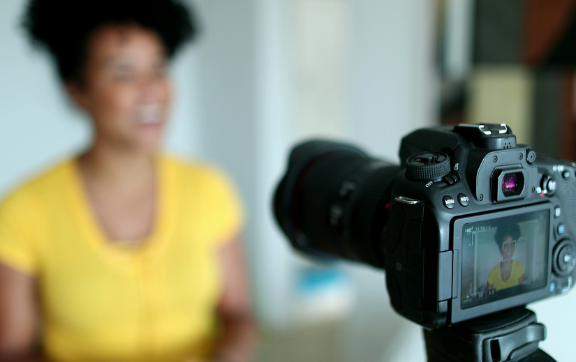 Creator de conținut care înregistrează un videoclip cu o cameră DSLR, prezentând strategii de marketing afiliat pentru venituri pasive.