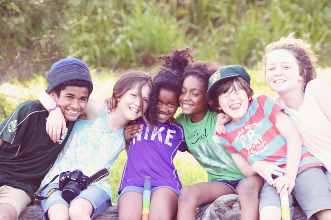 A diverse group of friends of different ethnicities and ages laughing and smiling together outdoors.