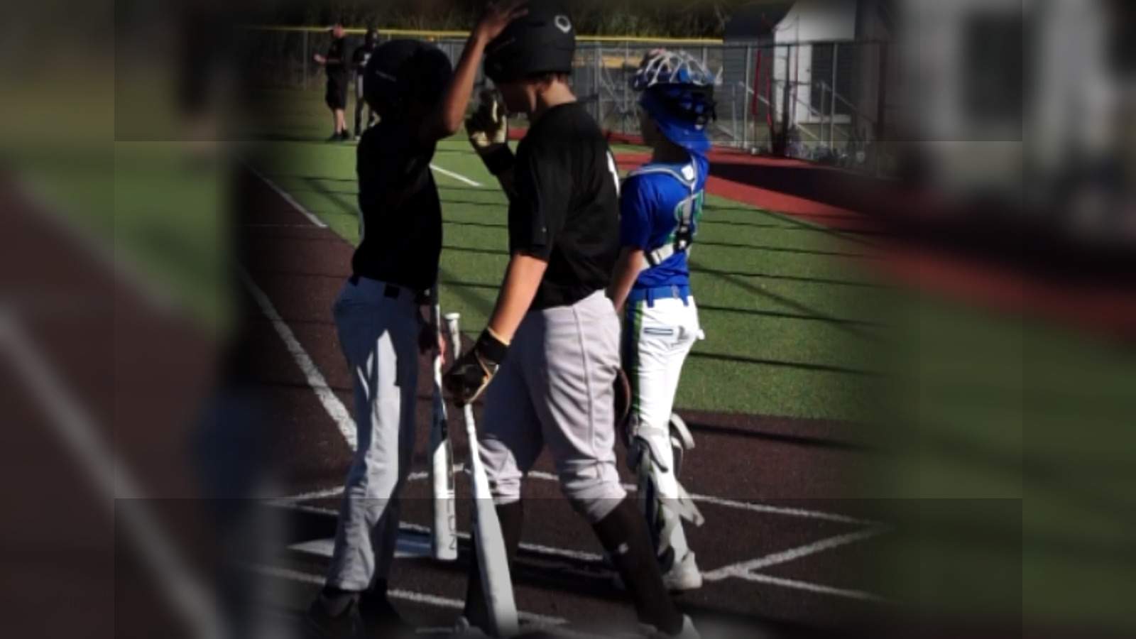 Youth baseball players on a field in a social-ready vertical composition
