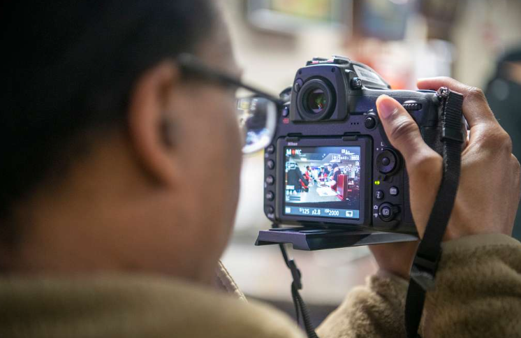 Osoba korzystająca z narzędzi do marketingu wideo, aby uchwycić profesjonalne ujęcia za pomocą aparatu DSLR