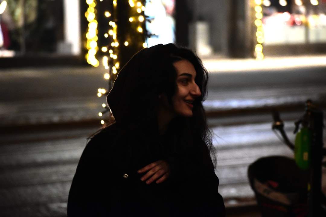 A person smiling warmly at another person, with a soft, blurred background.