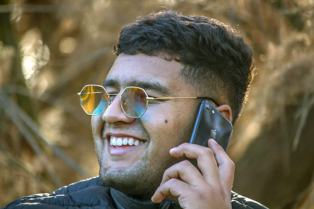 A person smiling while reading a birthday message on their phone.