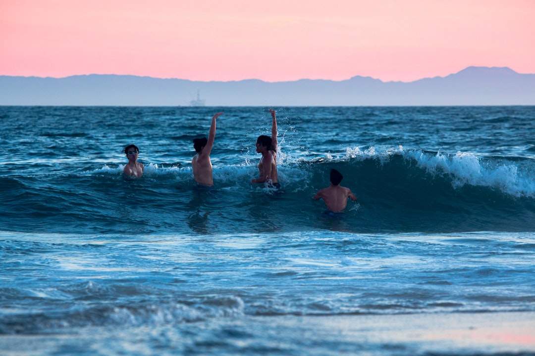 A group of friends laughing and splashing in the ocean waves.