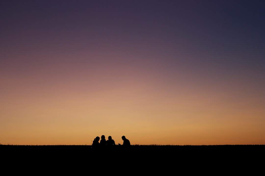 A silhouette of a family watching the sunset together, conveying a sense of hope and inspiration.