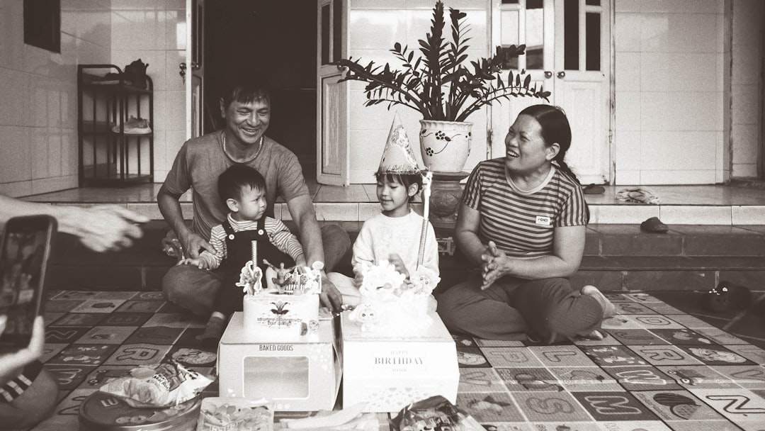 Isang pamilya ang nagtipon sa paligid ng isang birthday cake, nakangiti.