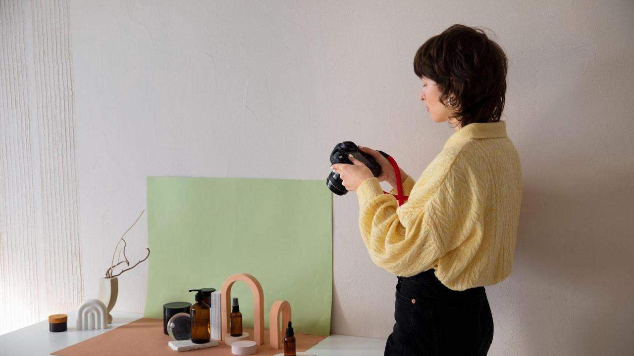 A woman photographs a styled product arrangement