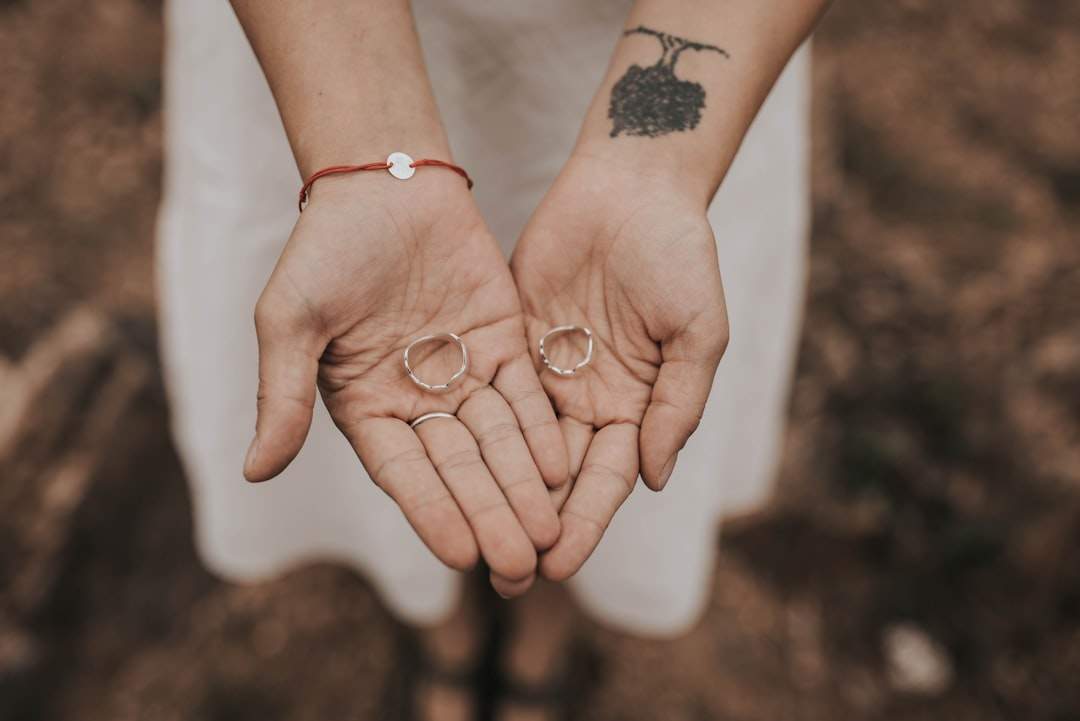 Due mani che tengono una pietra a forma di cuore, che simboleggia amore e cura.