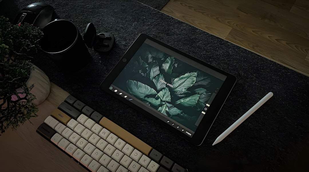 An artist's desk with a drawing tablet displaying pixel art, with coffee and plants nearby
