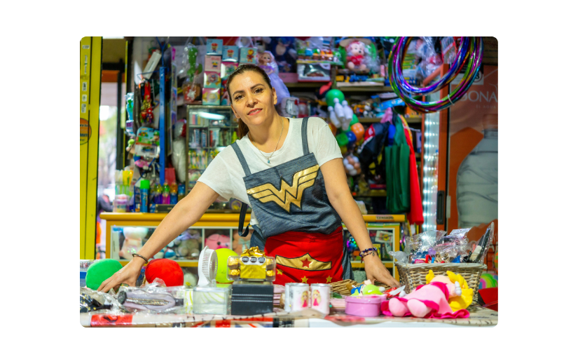Woman in Wonder Woman-Shirt hinter der Theke eines Spielzeugladens, um die Marketingstrategien von Etsy mit verschiedenen Produkten zu demonstrieren.