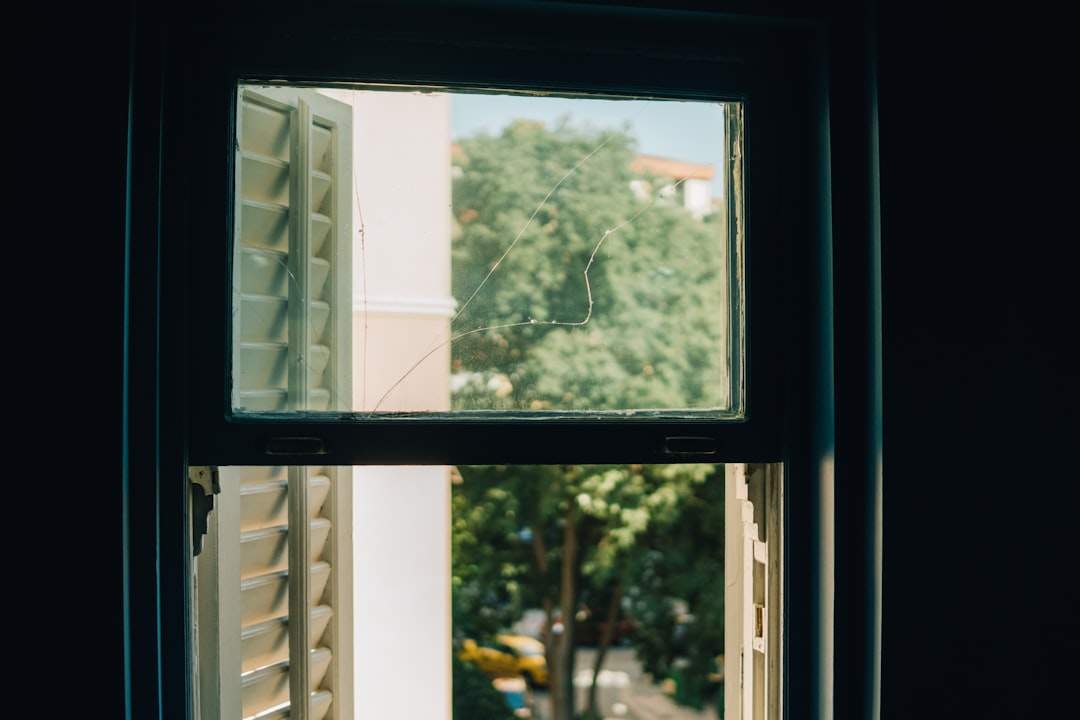 A person happily looking out a window on a sunny Friday afternoon