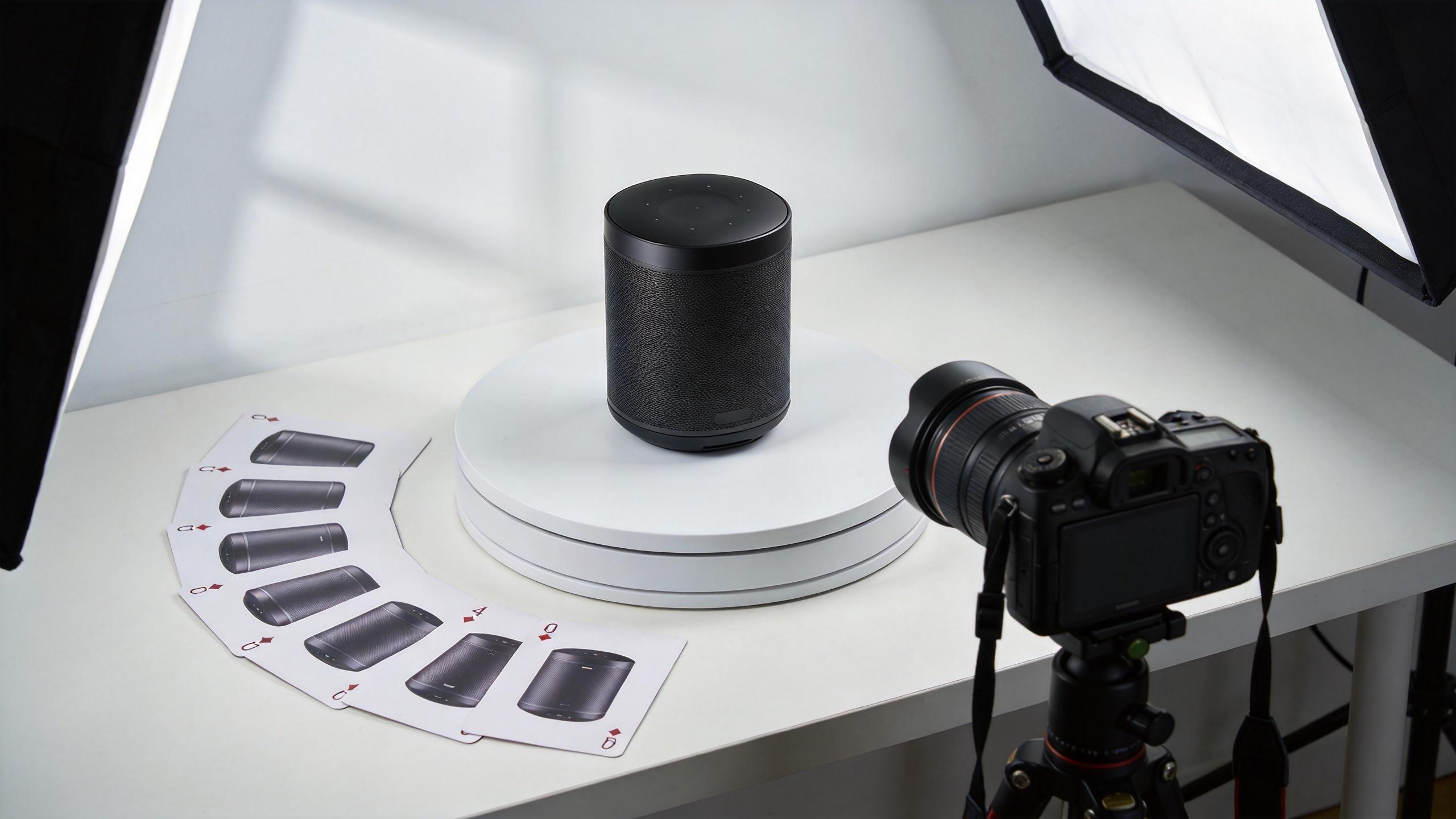 Camera photographing a speaker on a turntable with lighting and reference photos