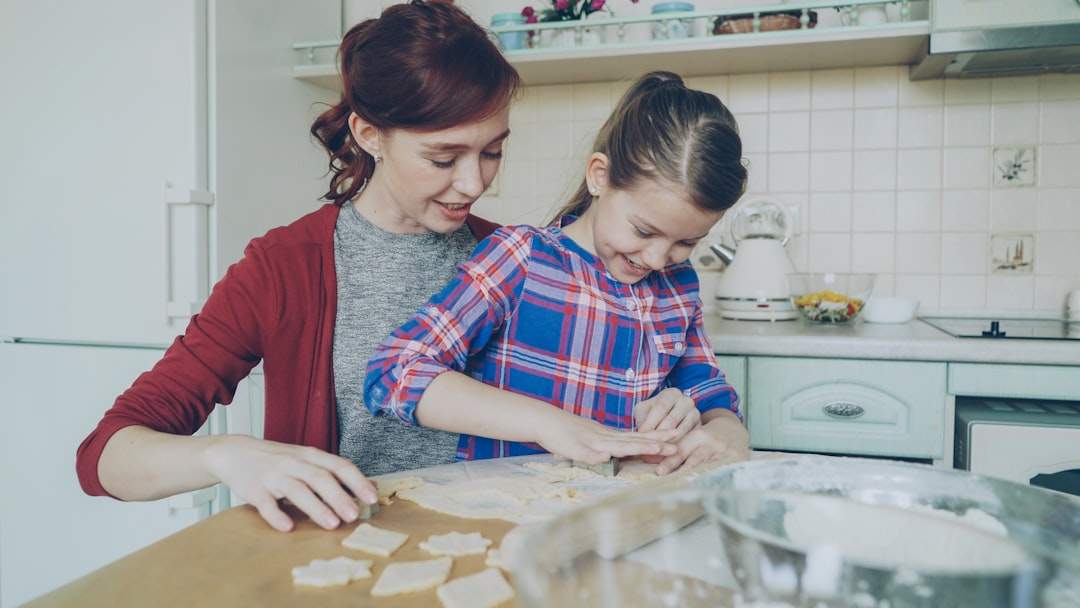 a mother and daughter laughing together, perhaps while doing a fun activity like baking or shopping
