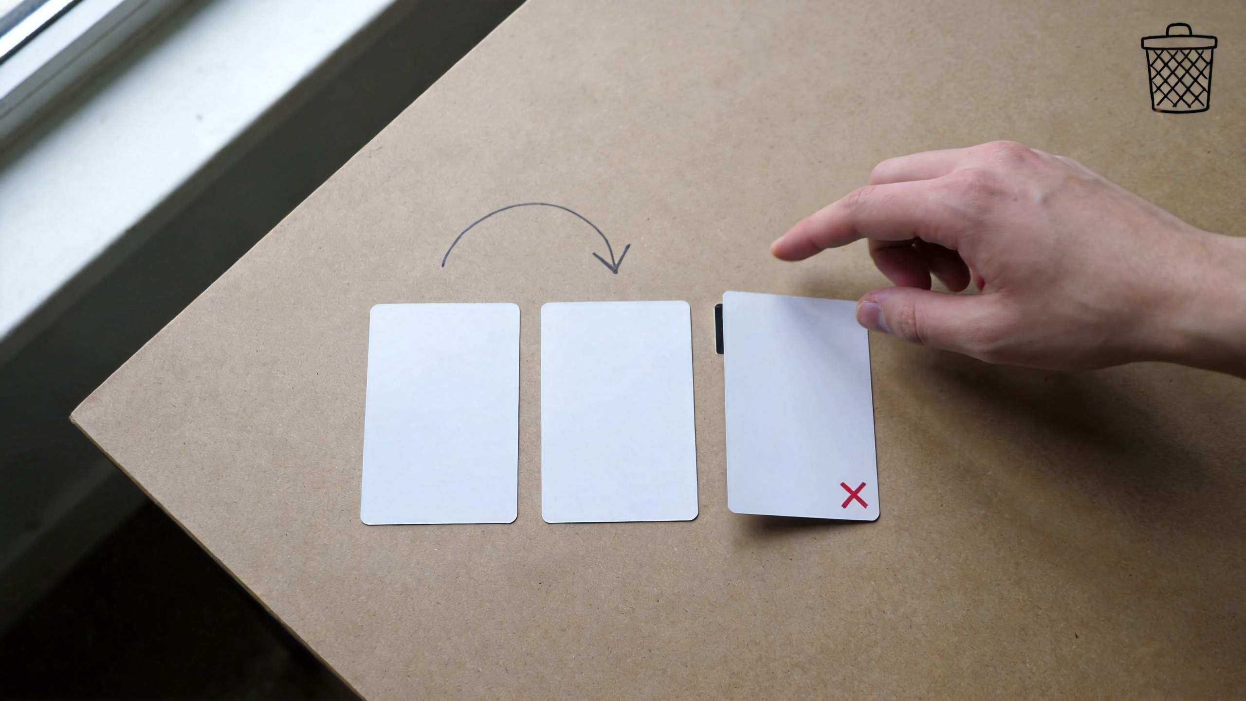 Hand moving a card from one blank card to another, with a red X on the last card