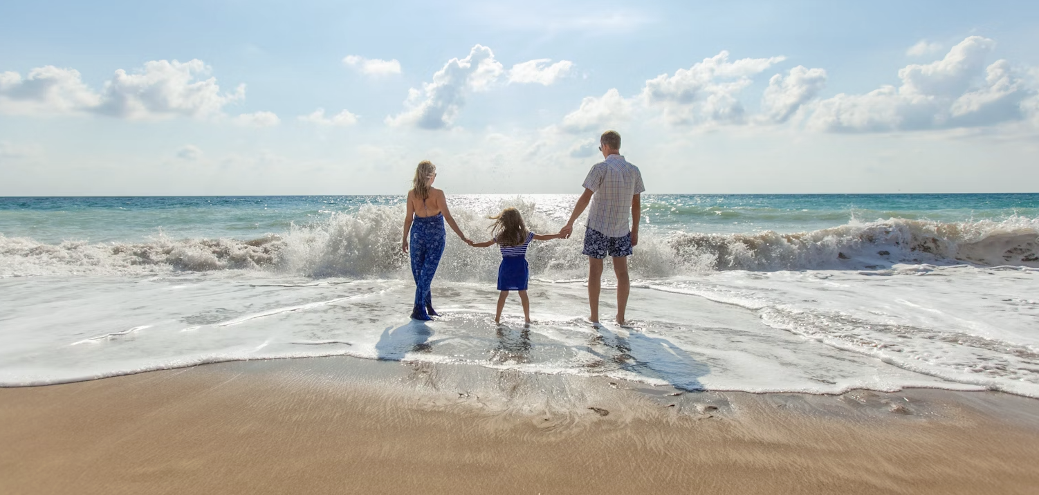 A happy family of four is having a picnic on the grass, with a warm and harmonious atmosphere.