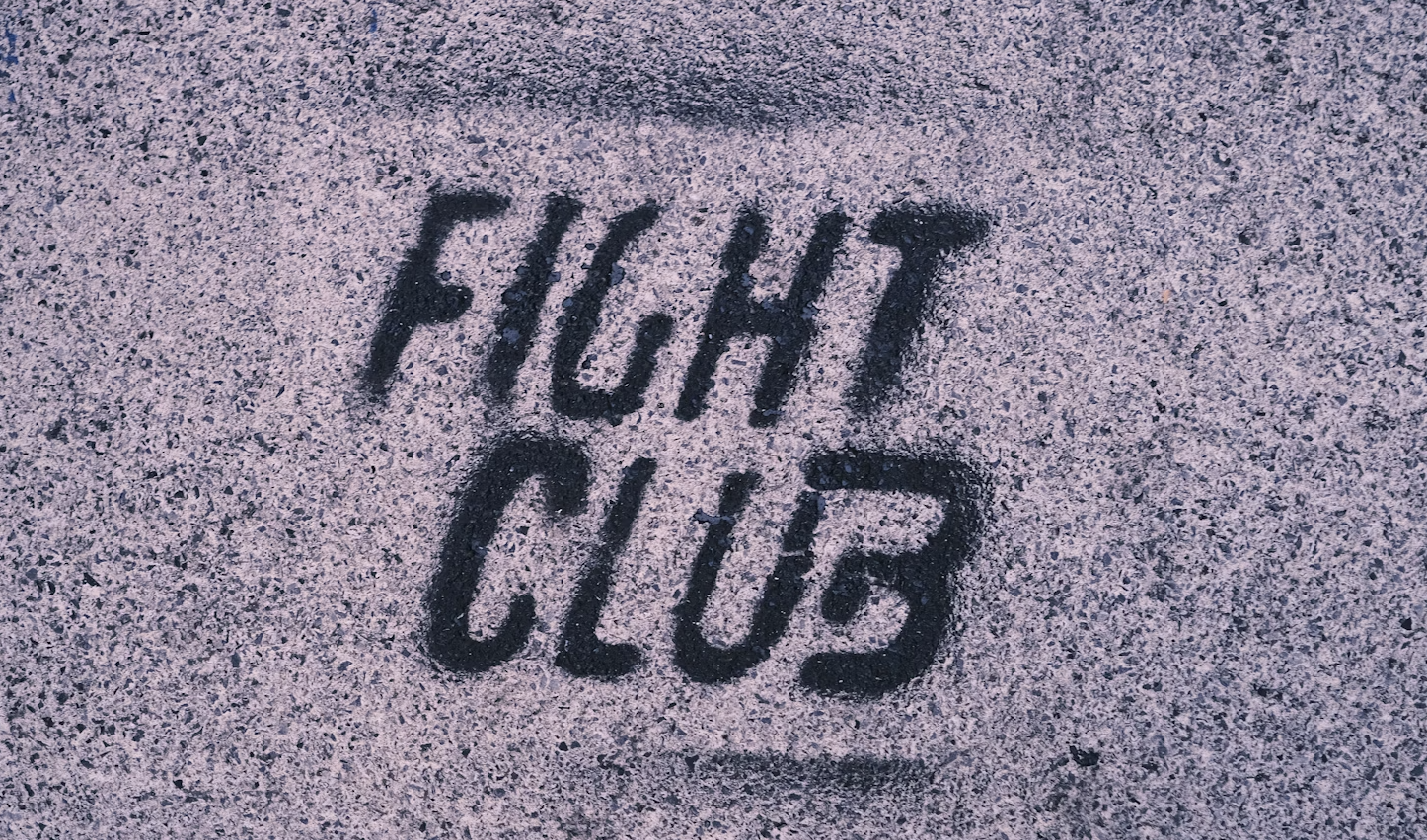 An iconic, gritty image from the movie Fight Club, possibly featuring Brad Pitt as Tyler Durden or a split image of the Narrator and Tyler. The tone should be dark and intense, with a rebellious feel, capturing the essence of the film.