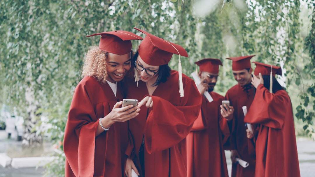 A group of friends laughing and taking a selfie at their graduation.
