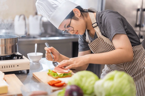 Chef cooking in busy kitchen with ingredients and utensils