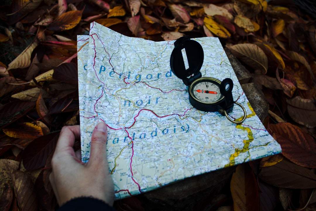 Открытая книга со старинной картой и компасом поверх нее.