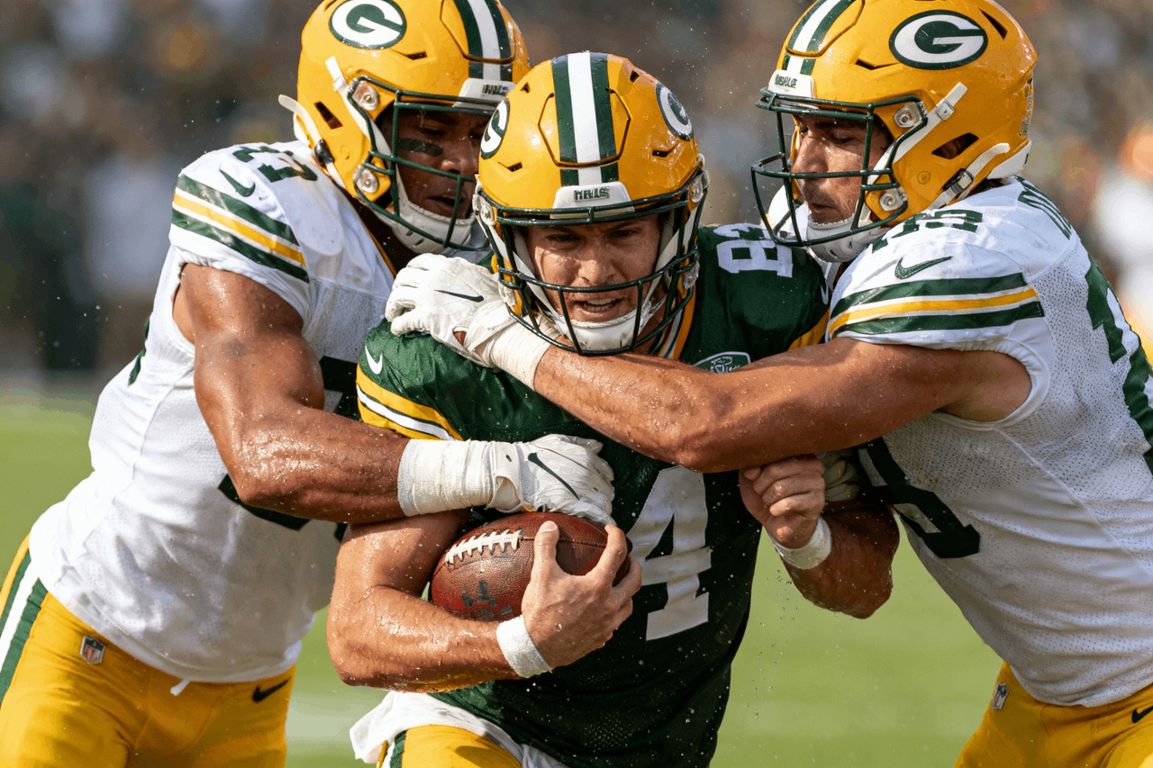 Three strong athletes fiercely competing for a rugby ball