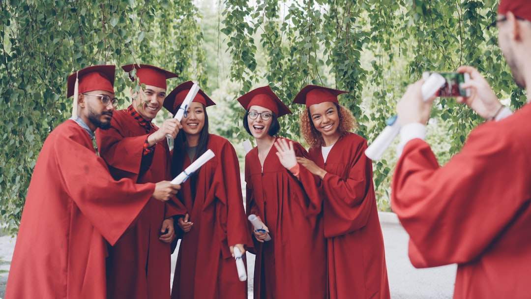A group of high school seniors in graduation gowns, laughing and celebrating.