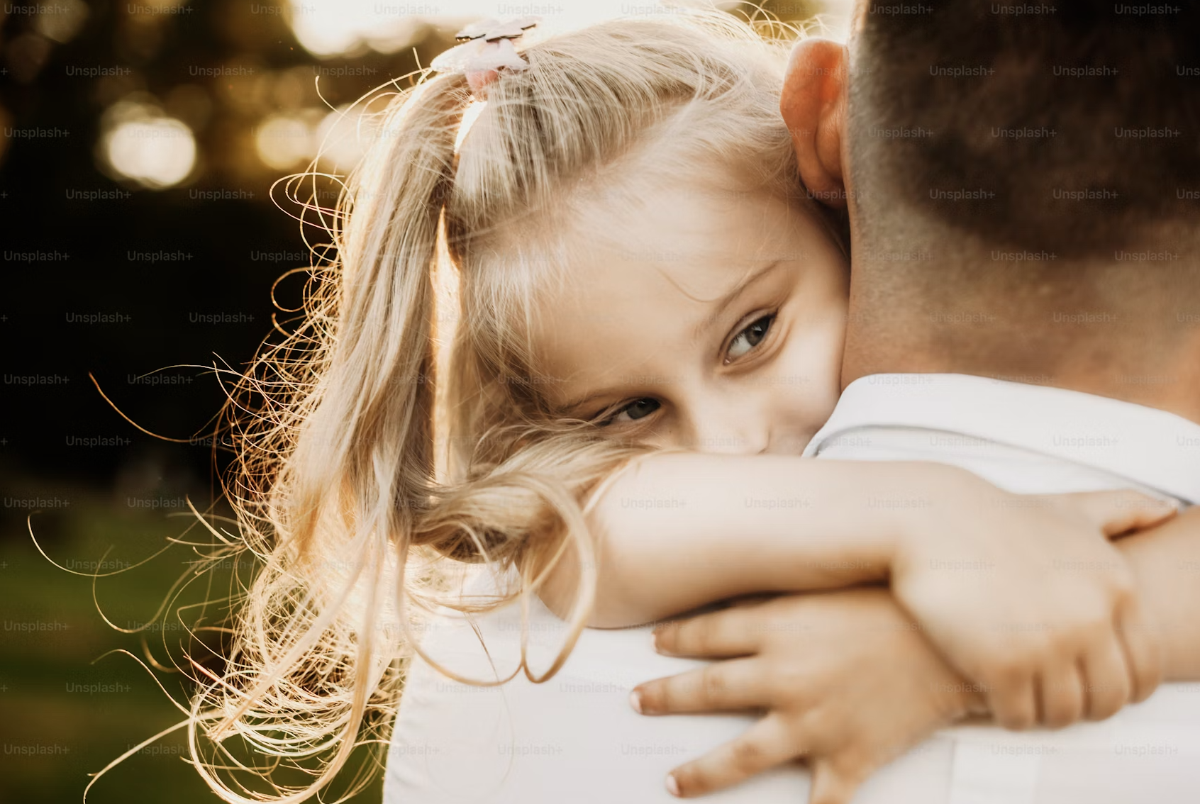 أب وابنته يسيران جنبًا إلى جنب في حديقة عند غروب الشمس.