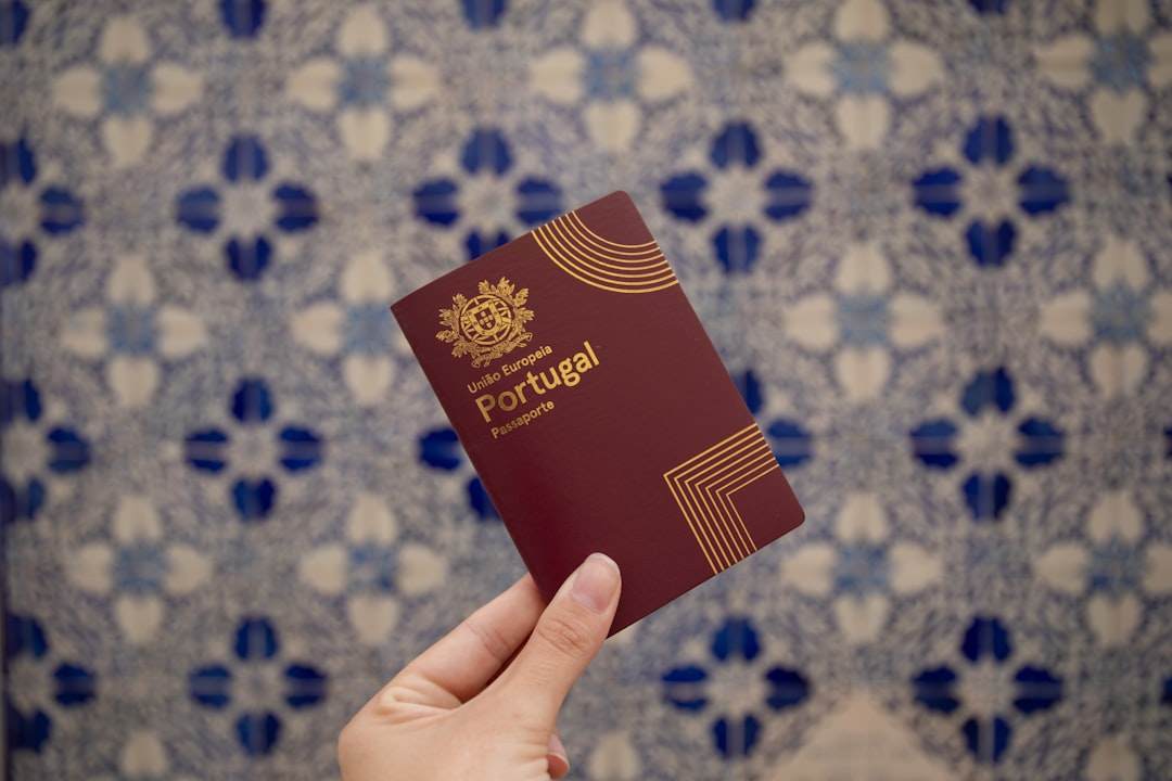 Крупный план паспорта с несколькими штампами, лежащий на красочной карте мира.