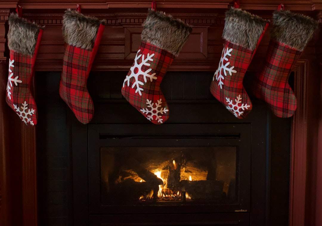 A cozy fireplace decorated with Christmas stockings and garlands