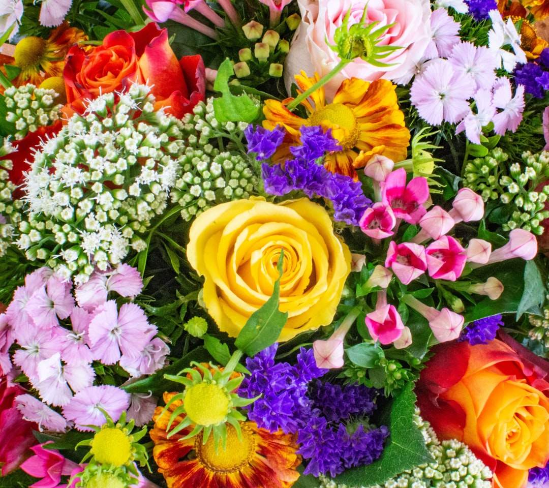 En vackert designad bild med texten 'Happy Birthday Mom' omgiven av blommor och mjuka, varma färger. Den övergripande känslan bör vara kärlek och fest.