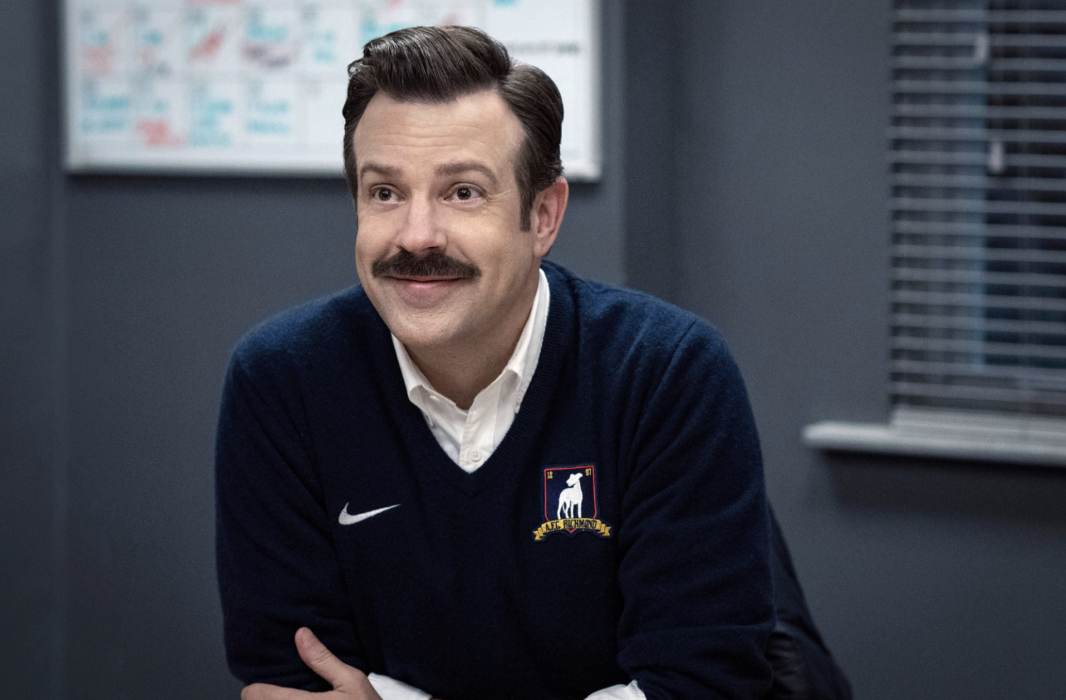 a person sitting on a blue chair in a stadium