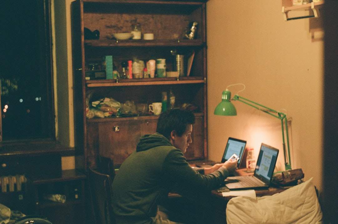 A person editing a video on a laptop in a cozy home office setting.