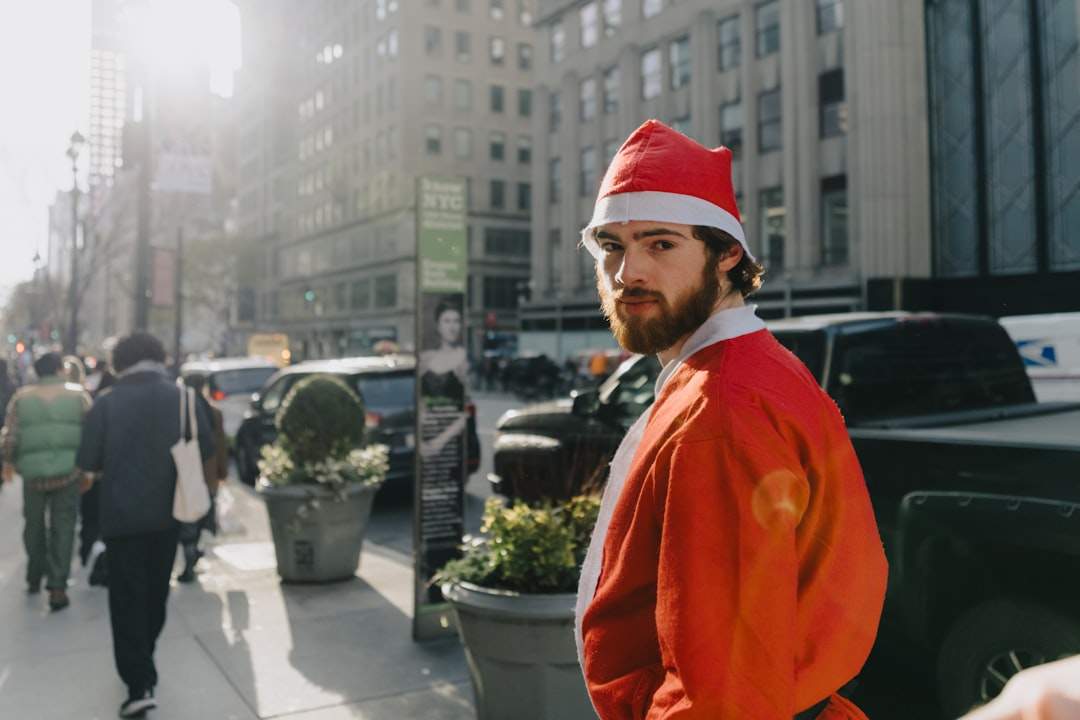 Buddy the Elf looking amazed and confused in the middle of a busy New York City street, with yellow cabs and skyscrapers in the background.
