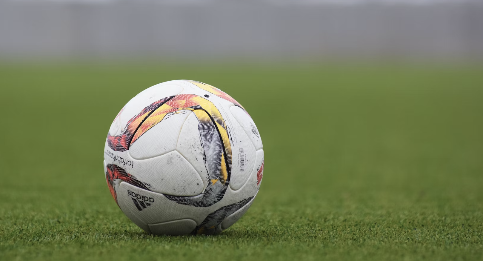A powerful image of a football player celebrating a victory on the field, with a stadium and cheering crowd in the background. The image should be vibrant and full of energy, with a focus on the emotion of the moment. The lighting should be dramatic, with the player illuminated by stadium lights. The overall feel should be inspiring and motivational, capturing the passion of the game.