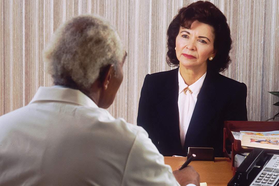 A friendly insurance agent is talking to a client in an office.