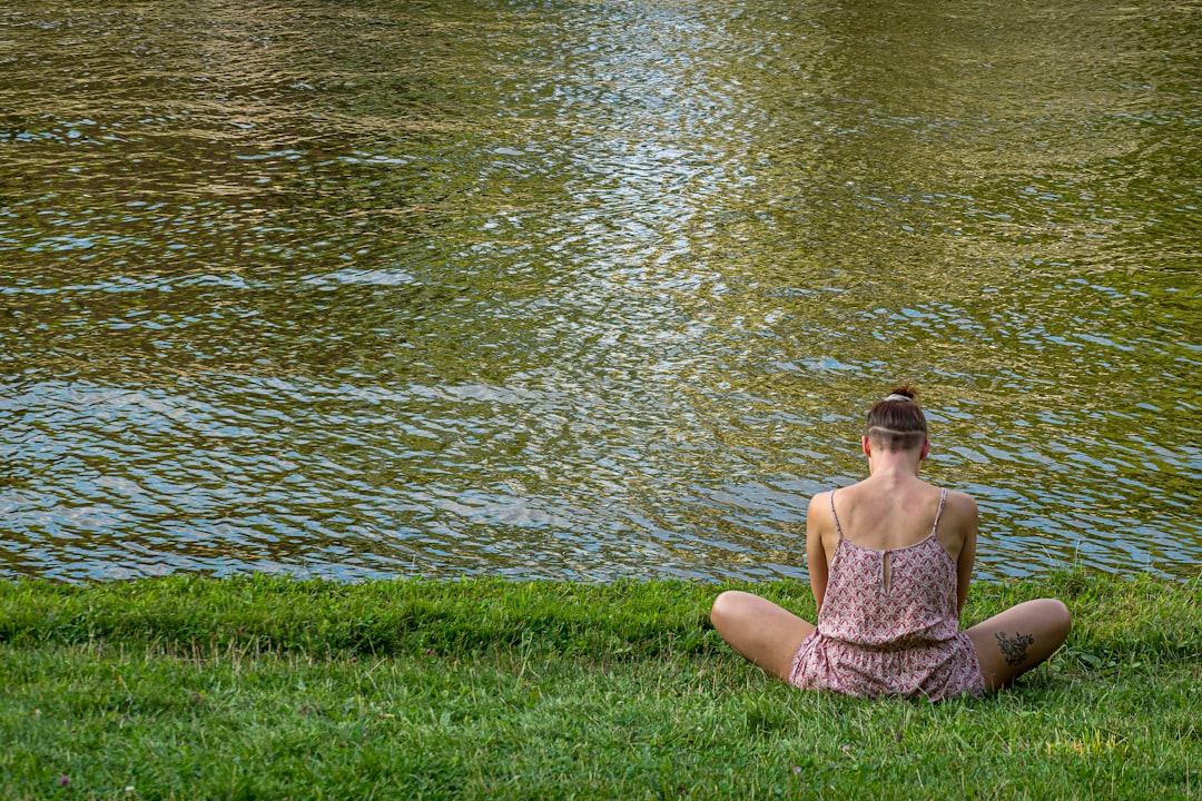 Een persoon die in een yogahouding zit in een serene en natuurlijke omgeving.