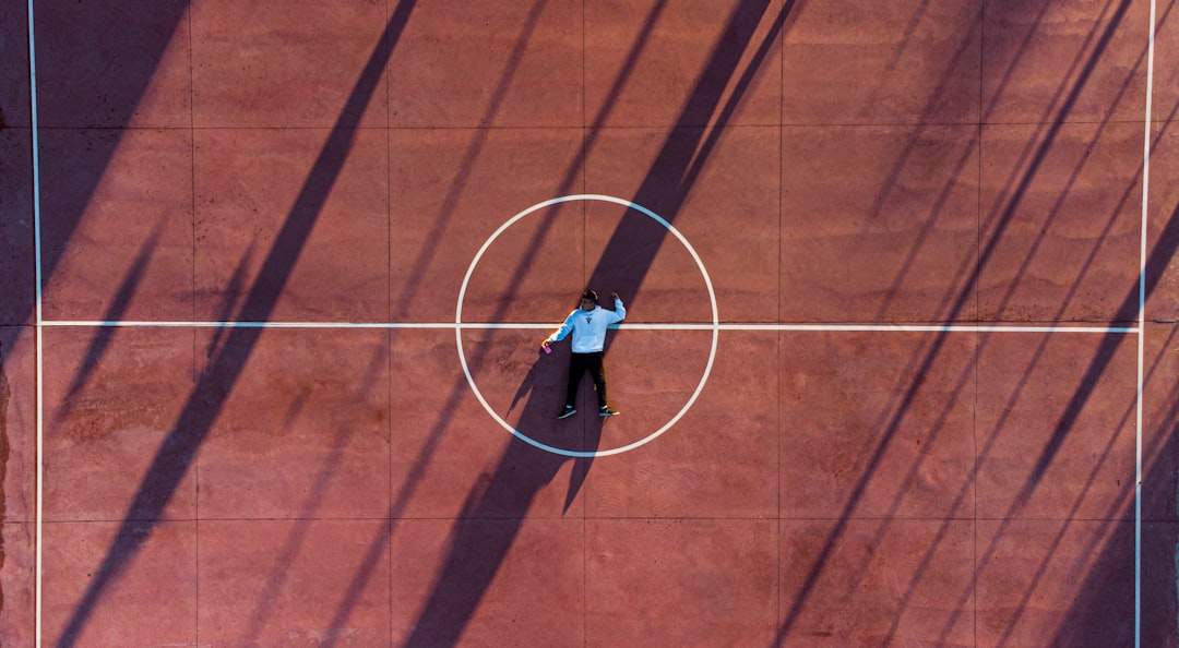 Una toma dramática de un campo de béisbol desde la perspectiva de un jugador saliendo del banquillo, simbolizando un viaje y un desafío por delante.